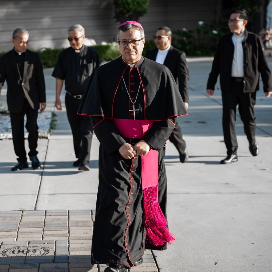 Bishop Alberto Rojas walking toward the camera with priests behind him
